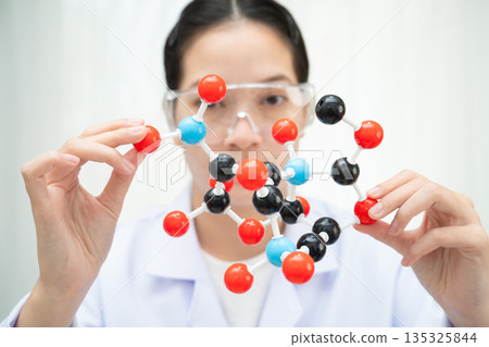 Scientist holding molecular model for chemical technology. 135325844