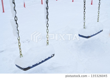 A swing in a snowy park A swing in a snowy park 135326045