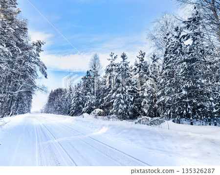 Winter landscape with road covered with snow in the forest Winter landscape with road covered with snow in the forest 135326287