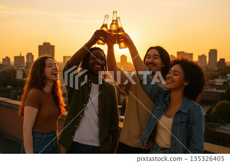 Friends gather on a rooftop at sunset to celebrate with drinks during a warm evening in the city 135326405