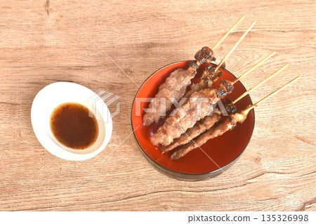 grilled salty beef meat stabbing in wooden stick on bowl dipping spicy tamarind chili sauce 135326998