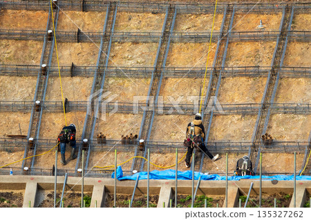 工人們繫上繩索，在斜坡上作業以確保安全。 135327262