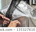 A woman getting a haircut at a beauty salon A woman getting a haircut at a beauty salon 135327610
