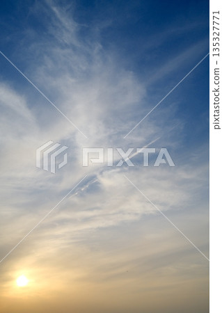 A gradient of light and clouds spreads across the evening sky, creating a soft and gentle hue. A gradient of light and clouds spreads across the evening sky, creating a soft and gentle hue. 135327771