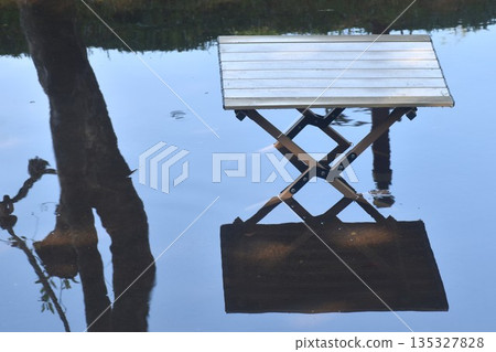 close up of wooden table on canal for sitting and relaxing in garden close up of wooden table on canal for sitting and relaxing in garden 135327828