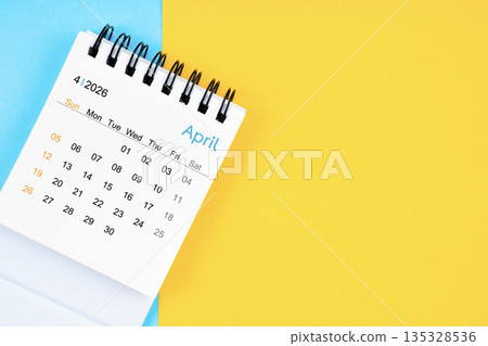 April 2026, Monthly desk calendar for 2026 year on yellow and blue background. 135328536