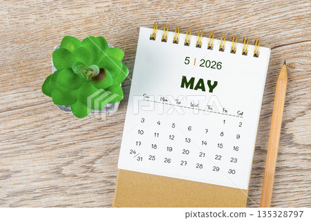 May 2026 monthly desk calendar and pencil with plant pot decoration. 135328797