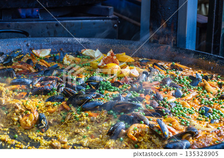 Traditional Spanish Seafood Paella Cooking in Large Pan 135328905