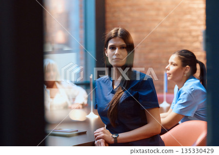 Healthcare professionals engaged in discussion within a modern clinic setting during daylight hours Healthcare professionals engaged in discussion within a modern clinic setting during daylight hours 135330429