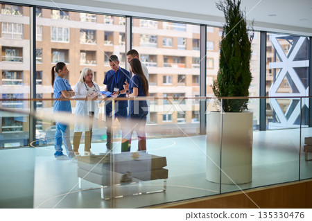 Healthcare team collaborates inside a modern hospital during the day 135330476