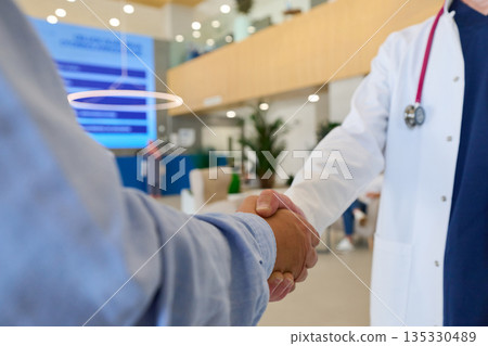 Handshake between doctor and patient in a modern healthcare facility during an appointment for medical consultation 135330489
