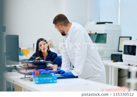 Laboratory team engaged in discussion about research project in a modern laboratory setting 135330512