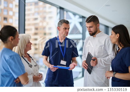 Healthcare professionals discuss patient care strategies in a modern hospital setting during a morning shift Healthcare professionals discuss patient care strategies in a modern hospital setting during a morning shift 135330519
