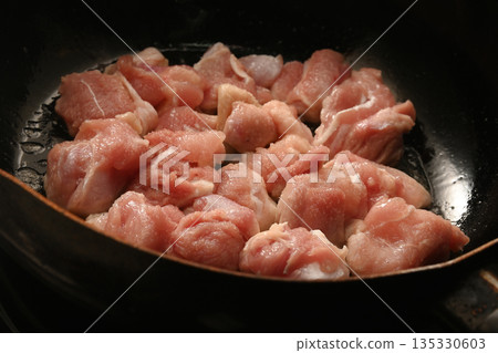 Juicy chicken thighs fried in a frying pan 135330603