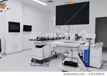 Modern surgical room with advanced medical equipment and sterile environment in a healthcare facility Modern surgical room with advanced medical equipment and sterile environment in a healthcare facility 135330614