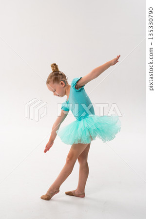 A young dancer with a cochlear implant bends forward in a turquoise ballet costume. Adaptive performance, hearing technology, and physical coordination through classical dance and therapy. A young dancer with a cochlear implant bends forward in a turquoise ballet costume. Adaptive performance, hearing technology, and physical coordination through classical dance and therapy. 135330790