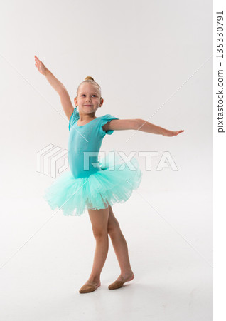 A smiling ballerina with a cochlear implant poses in a turquoise tutu on stage. Inclusive ballet, hearing support, and self expression through classical dance and childhood performance. A smiling ballerina with a cochlear implant poses in a turquoise tutu on stage. Inclusive ballet, hearing support, and self expression through classical dance and childhood performance. 135330791