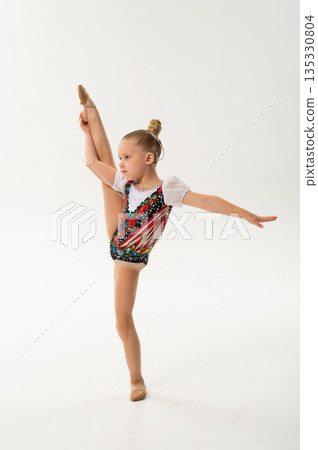 Talented dancer with a cochlear implant lifts her leg in a high gymnastic pose. Adaptive athletics, auditory technology, and youth empowerment through rhythmic gymnastics and ballroom movement. Talented dancer with a cochlear implant lifts her leg in a high gymnastic pose. Adaptive athletics, auditory technology, and youth empowerment through rhythmic gymnastics and ballroom movement. 135330804