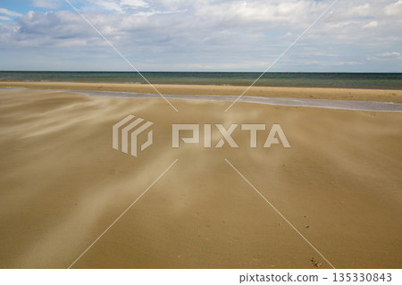 A gust of wind blowing over the beach A gust of wind blowing over the beach 135330843