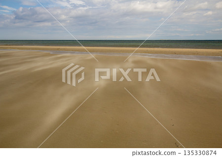 A gust of wind blowing over the beach A gust of wind blowing over the beach 135330874