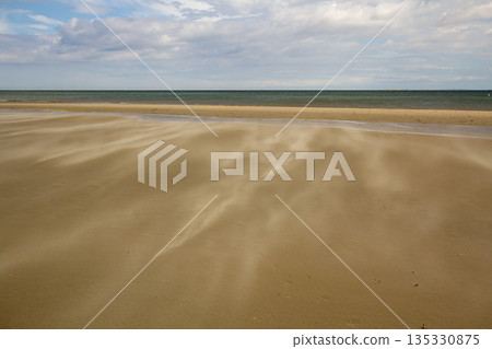 A gust of wind blowing over the beach A gust of wind blowing over the beach 135330875
