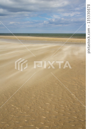 A gust of wind blowing over the beach A gust of wind blowing over the beach 135330878