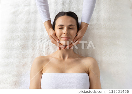 Top view of young beautiful woman enjoying facial spa treatment 135331466
