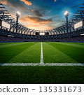 Sunset view of a large stadium with a green field and bright lights during a sports event 135331673