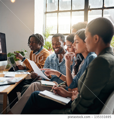 People working together in a group in a bright office space during the day while sharing ideas and discussing plans 135331695