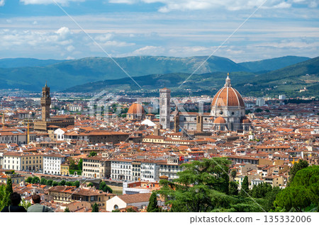 Panoramic view of Florence (Firenze), Italy, showing rooftops, landmarks like Palazzo Vecchio and Santa Maria del Fiore with its red dome, and hills with forests on a sunny summer day. Panoramic view of Florence (Firenze), Italy, showing rooftops, landmarks like Palazzo Vecchio and Santa Maria del Fiore with its red dome, and hills with forests on a sunny summer day. 135332006