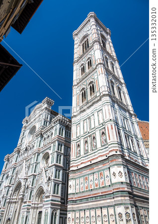 Detailed view of Santa Maria del Fiore cathedral in Florence, showing the iconic red dome and the nearby bell tower, highlighting the rich Renaissance architecture and historic elegance. Detailed view of Santa Maria del Fiore cathedral in Florence, showing the iconic red dome and the nearby bell tower, highlighting the rich Renaissance architecture and historic elegance. 135332010