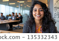 Young South Asian woman at a board meeting sharing ideas with confident gestures in an inclusive open-plan workspace 135332343
