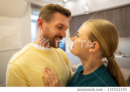 Cheerful couple man and woman looking at each other and smiling, enjoying bonding in relationships. 135332350
