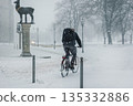 Cyclist rides heavy snowfall winter city altmarkt rathaus under low visibility conditions. Snow covered path cold weather urban solitude highlight daily commute, resilience and sustainable mobility 135332886