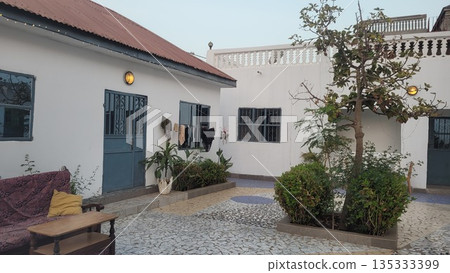 Gambian Quiet Courtyard with White Houses, Blue Doors and Hanging Laundry Gambian Quiet Courtyard with White Houses, Blue Doors and Hanging Laundry 135333399