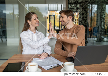 Two people working together on the project and looking excited Two people working together on the project and looking excited 135333512