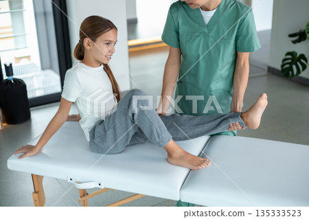 Professional healthcare worker guiding patient in movement therapy Professional healthcare worker guiding patient in movement therapy 135333523