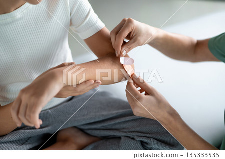 Child patient getting arm treated by nurse during checkup Child patient getting arm treated by nurse during checkup 135333535