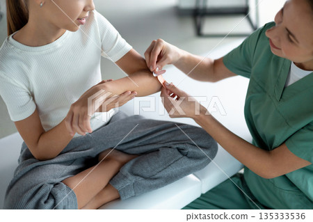 Medical professional providing wound care for child Medical professional providing wound care for child 135333536