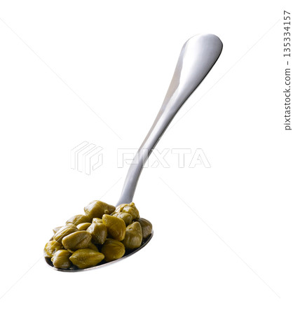 Spoon with pickled capers isolated on a white background. Spoon with pickled capers isolated on a white background. 135334157
