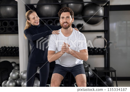 Blonde young female coach training a young man during interval workout Blonde young female coach training a young man during interval workout 135334187