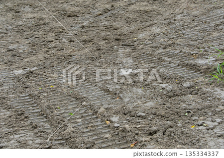 Tire marks from construction machinery left on muddy ground 135334337