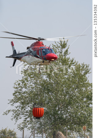 Helicopter Carrying Water Bucket for Firefighting Action 135334392