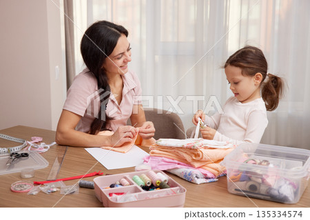 Mother and little daughter bonding, learning craft skills, and creating handmade items Mother and little daughter bonding, learning craft skills, and creating handmade items 135334574
