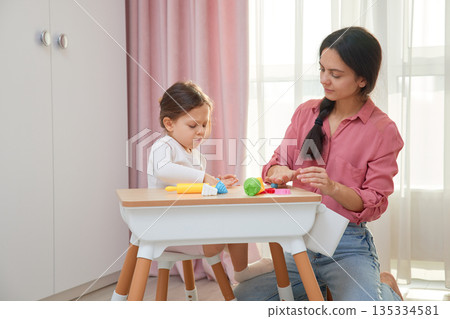 Mother and daughter enjoying creative learning time with modeling clay at home 135334581
