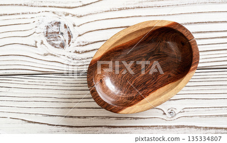 Small polished rosewood bowl on white boards desk, closeup view from above Small polished rosewood bowl on white boards desk, closeup view from above 135334807