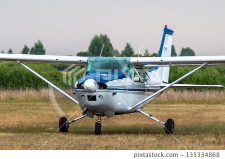 Front view of the small private aircraft with the engine running at the airfield Front view of the small private aircraft with the engine running at the airfield 135334868