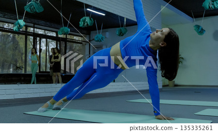 Woman doing side plank yoga pose Woman doing side plank yoga pose 135335261