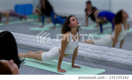 Group of women in cobra yoga pose Group of women in cobra yoga pose 135335282