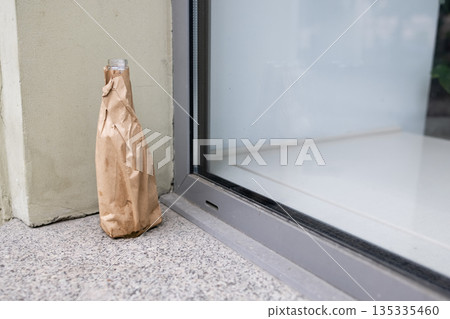 Alcohol bottle wrapped in paper packet 135335460